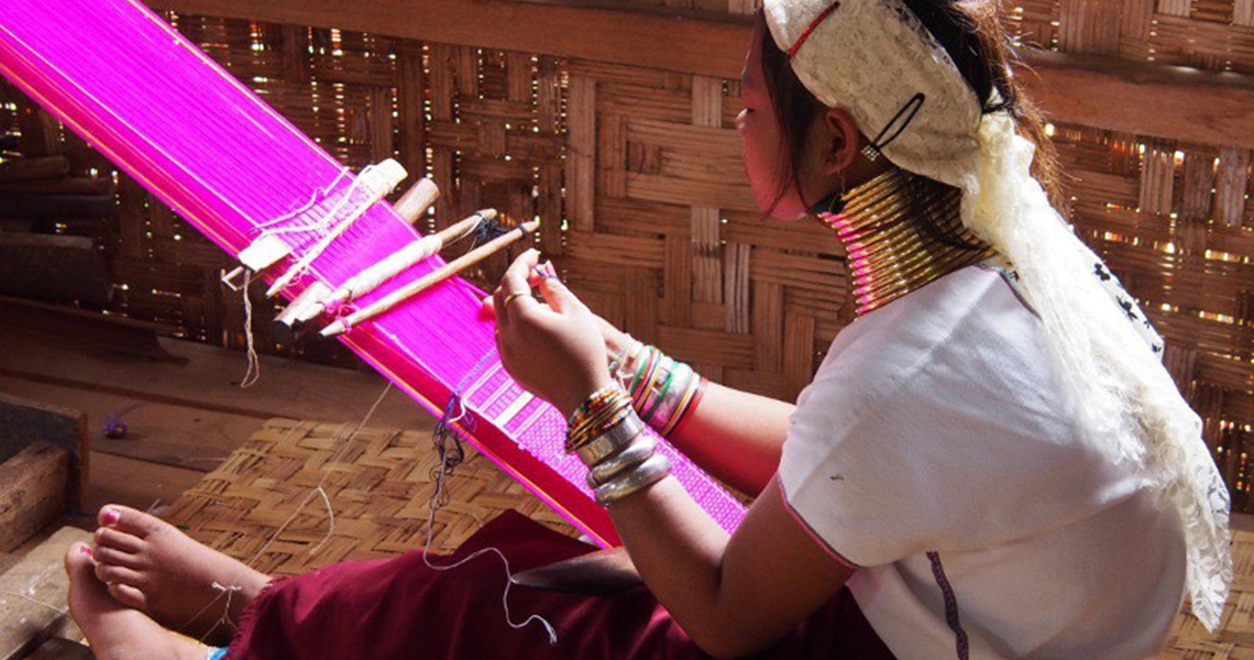 image of woman weaving a rug